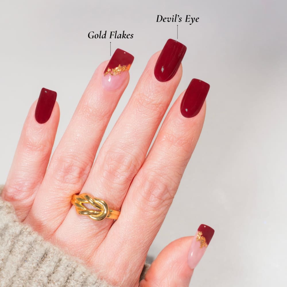 DIY-Maniküre mit DIPDRIP: Devil’s Eye (glänzendes Dunkelrot) und Gold Flakes (Klar mit goldenen Flocken) für ein auffälliges Nageldesign. Diese Farben sind perfekt für eine glamouröse und elegante Maniküre, die alle Blicke auf sich zieht. Ideal für festliche Anlässe oder einen luxuriösen Alltagslook